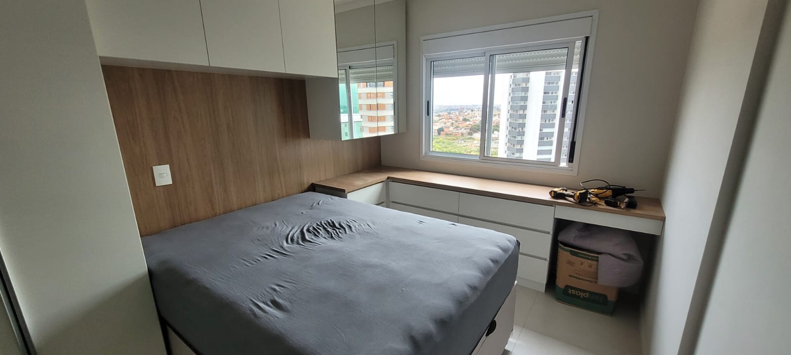 Quarto com painel de madeira e cabeceira estofada